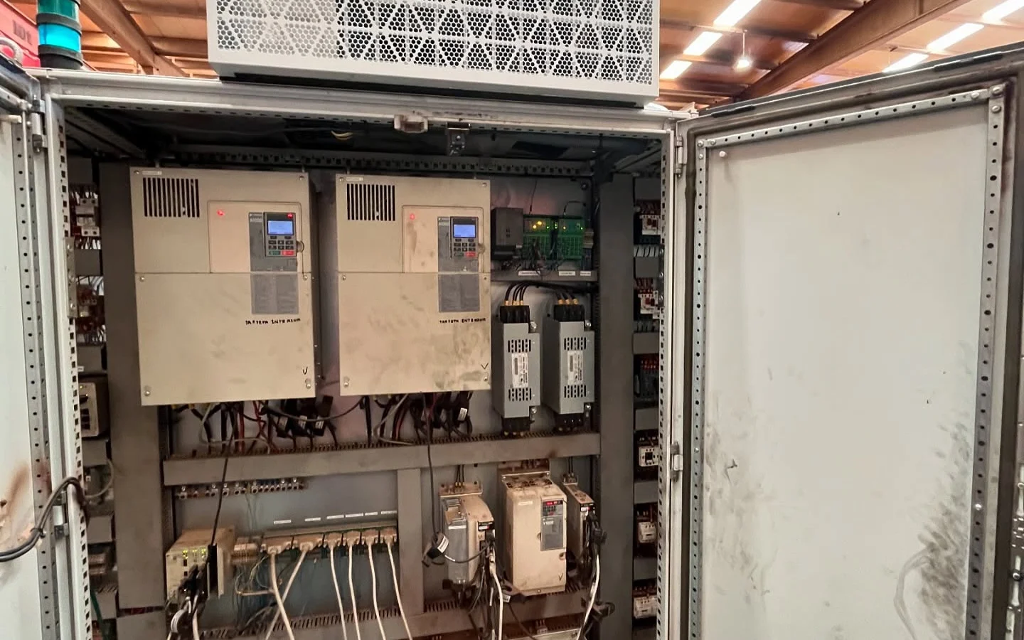 Equipo de refrigeración montado sobre un cuadro eléctrico industrial abierto con variadores de frecuencia